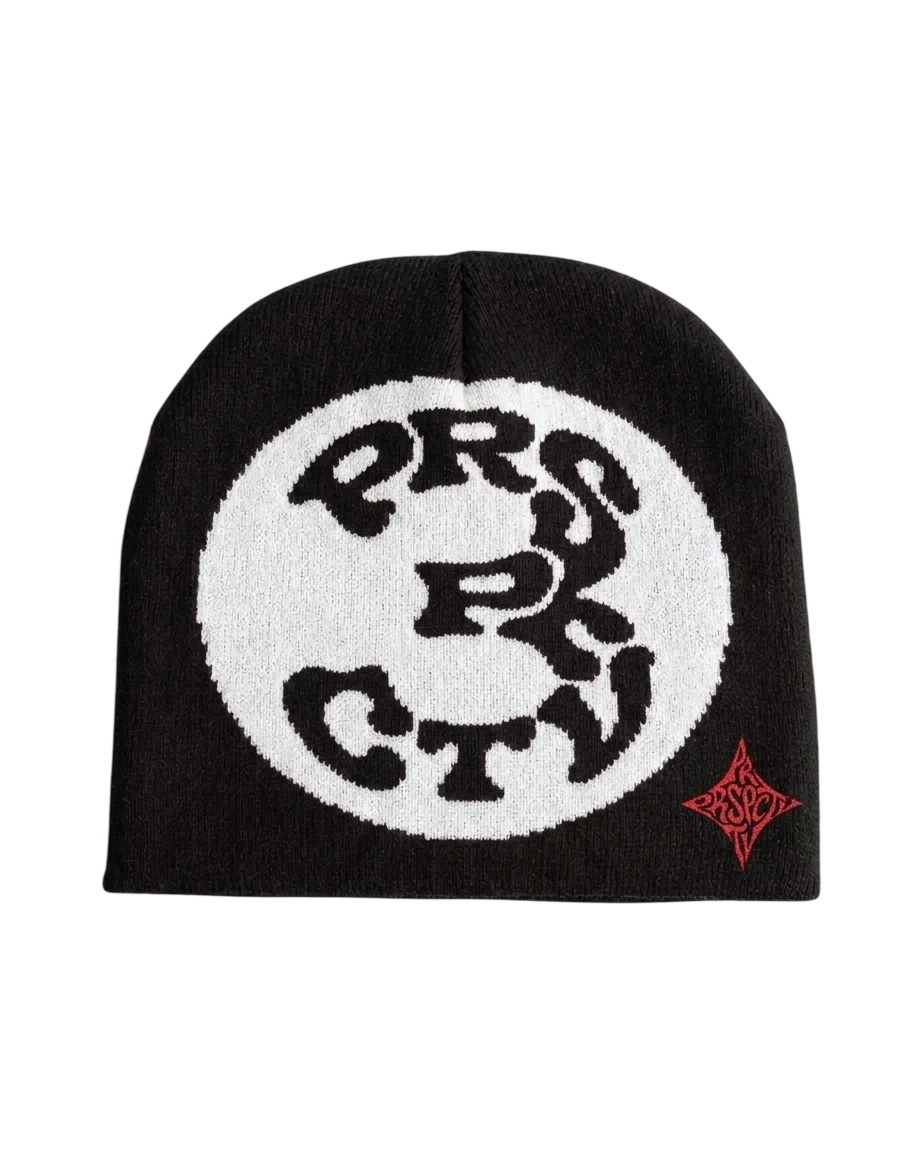 Bonnet noir en maille jacquard : un grand cercle blanc où les lettres PRSPCTV forment un 3, et le petit monogramme rouge en bas à droite